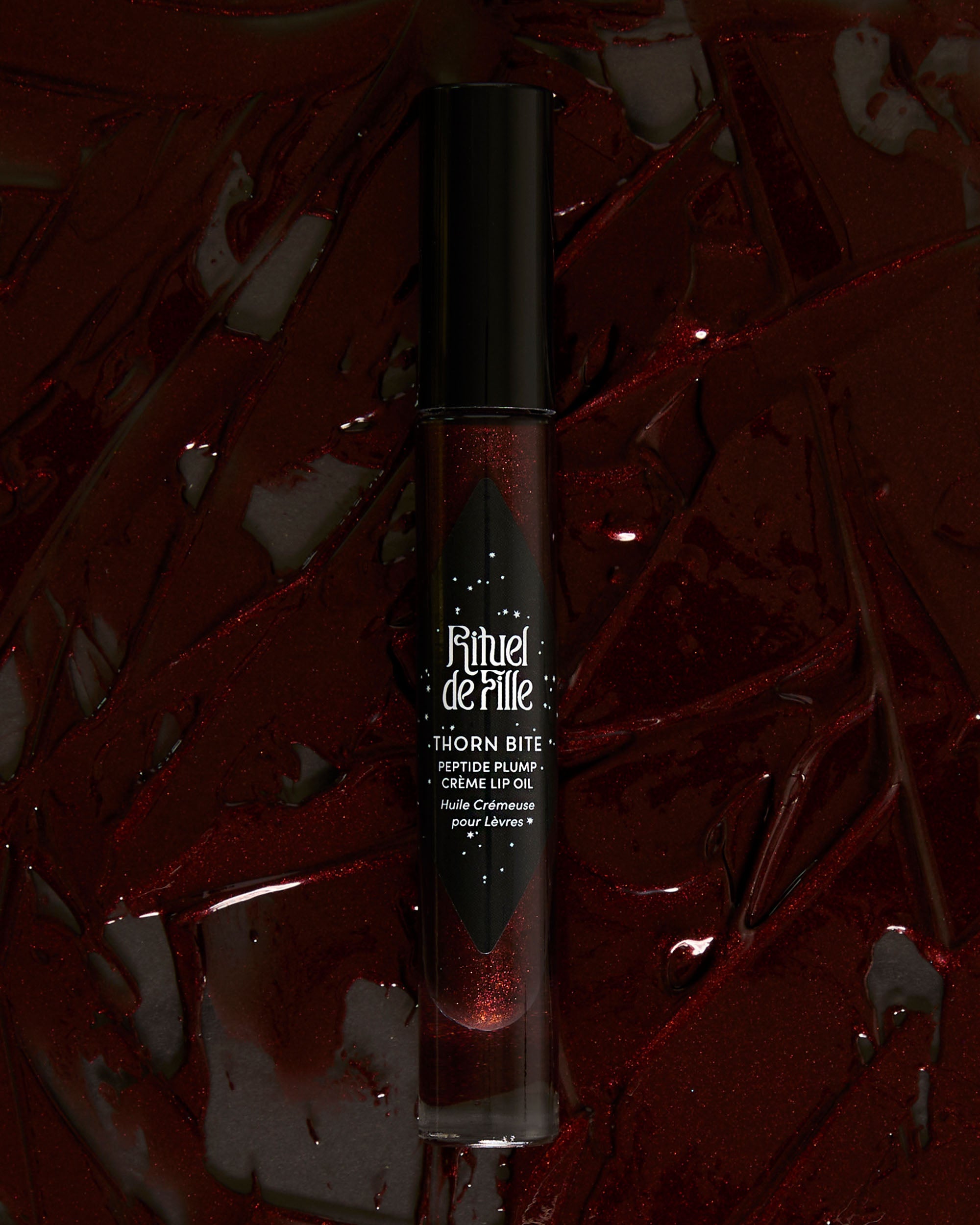 Styled campaign photo of Night Flower lip oil in use